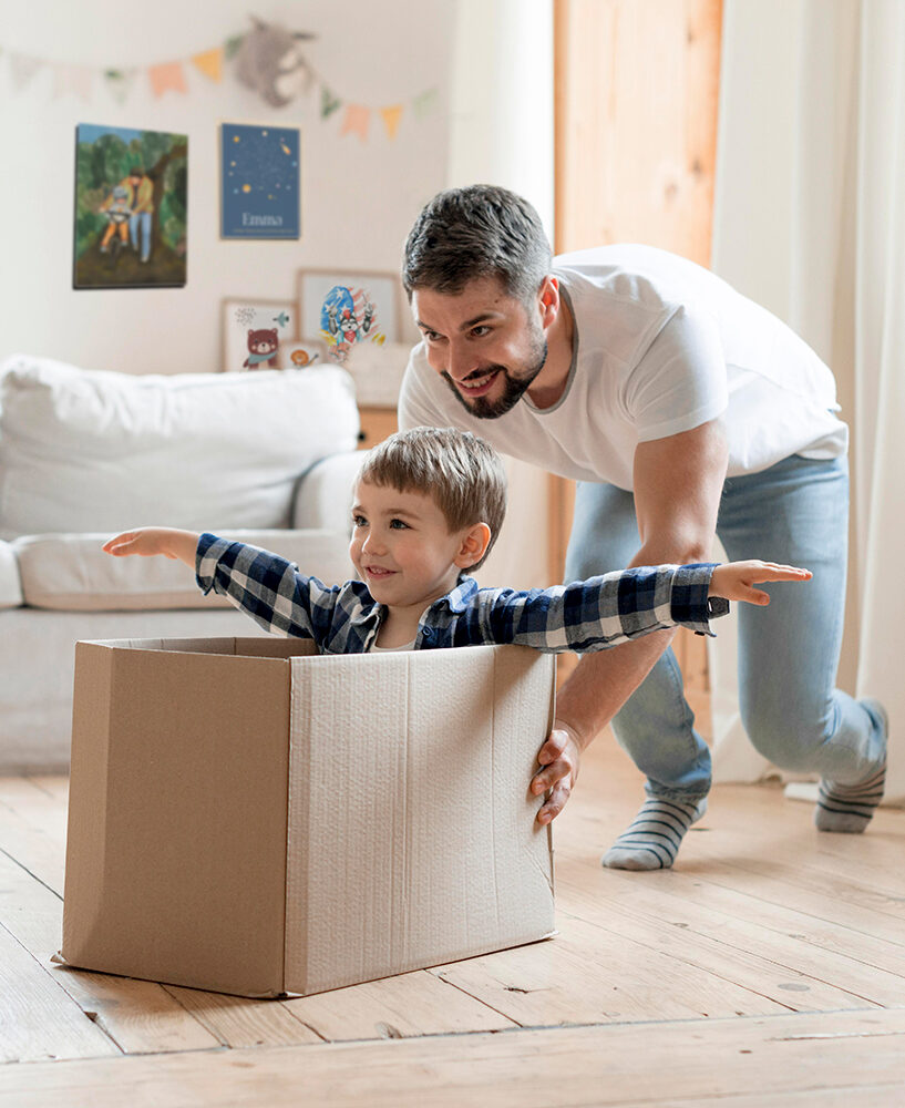 child father playing with box living room e1668564855123