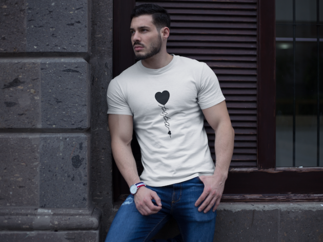 buff man wearing a t shirt mockup while lying against a wall a17659 2