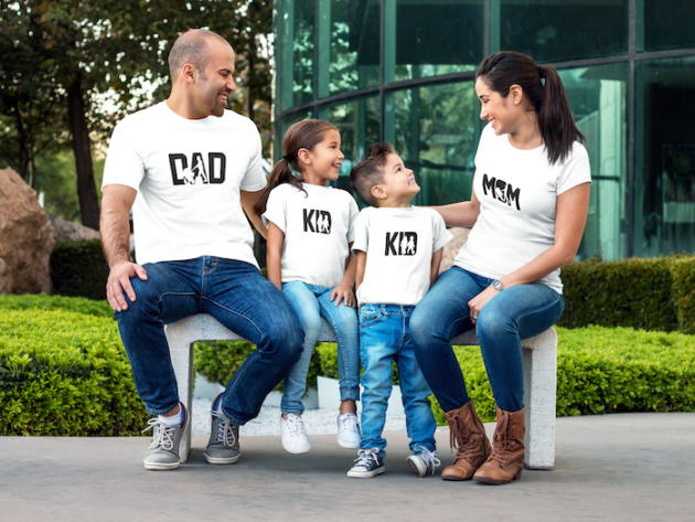 couple with kids wearing different tees mockup sitting on a bench while outdoors a15484