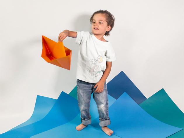 little kid playing with a paper boat while wearing a round neck tshirt template a16142