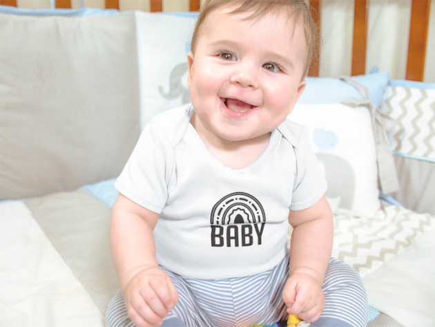 mockup of a smiling baby boy sitting in his crib while wearing a onesie a13959 2
