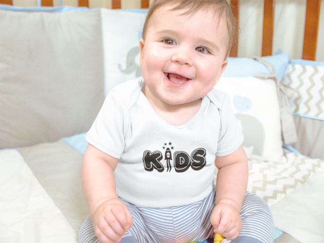 mockup of a smiling baby boy sitting in his crib while wearing a onesie a13959 3