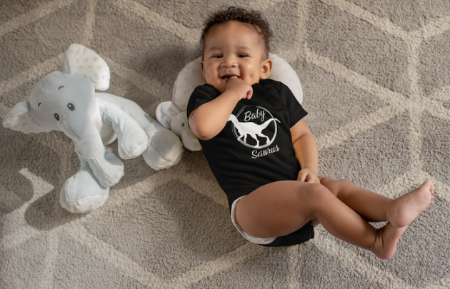 onesie mockup of a sweet baby boy with dimples next to his stuffed toys 25115 5