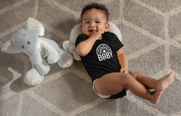 onesie mockup of a sweet baby boy with dimples next to his stuffed toys 25115 6