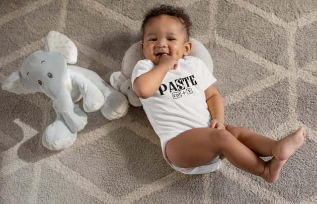 onesie mockup of a sweet baby boy with dimples next to his stuffed toys 25115