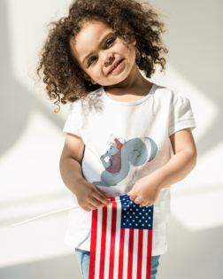 t shirt mockup of a little girl holding a flag of the united states m12283 r el2 2