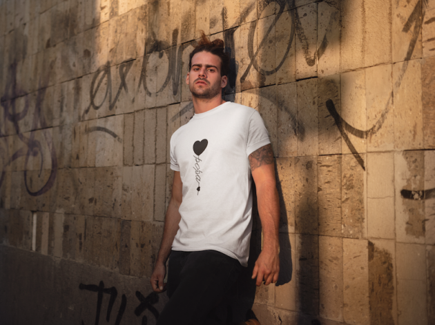 t shirt mockup of a man leaning on a graffiti painted wall 19946
