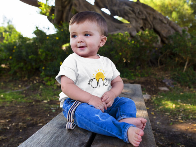 cute baby boy sitting down in a wooden bench while wearing a round neck tshirt template a16088